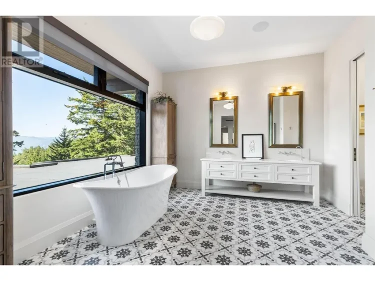 A well-lit bathroom showcasing a large bathtub beside a window.