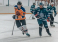 A team of hockey players on an ice rink, playing a competitive game.