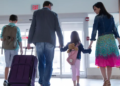 A family walking out of an airport together.