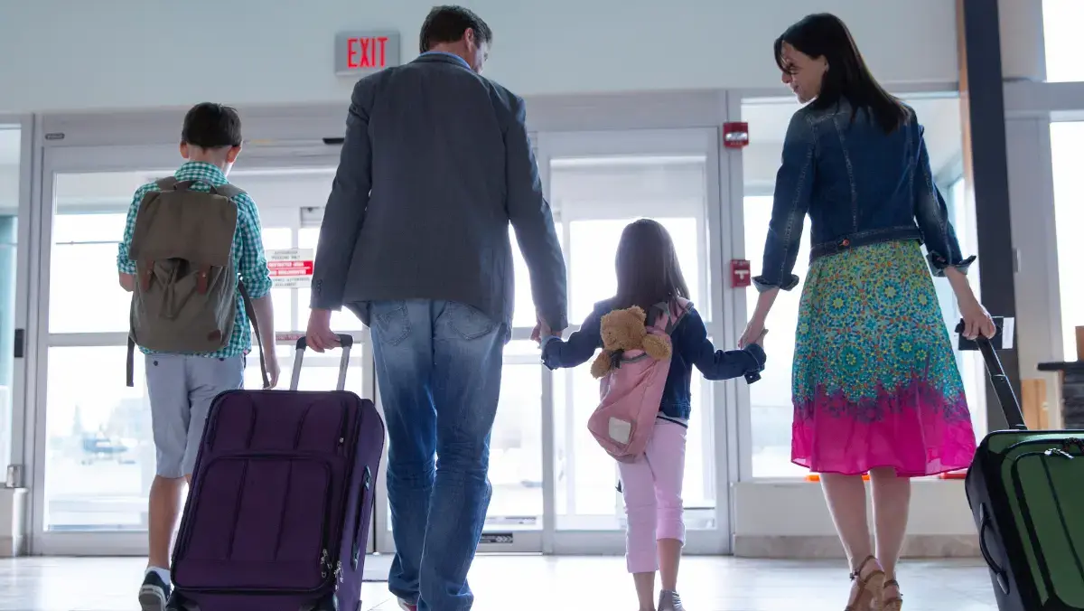 A family walking out of an airport together.