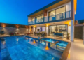 A sleek modern villa featuring a swimming pool and a spacious patio area.