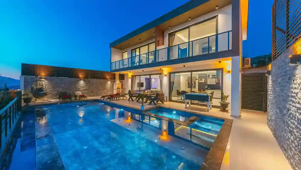 A sleek modern villa featuring a swimming pool and a spacious patio area.