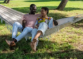 Two people sitting on a hammock together.