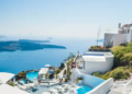 A scenic view of the sea and white buildings from a hilltop.