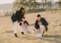 young family playing soccer with child