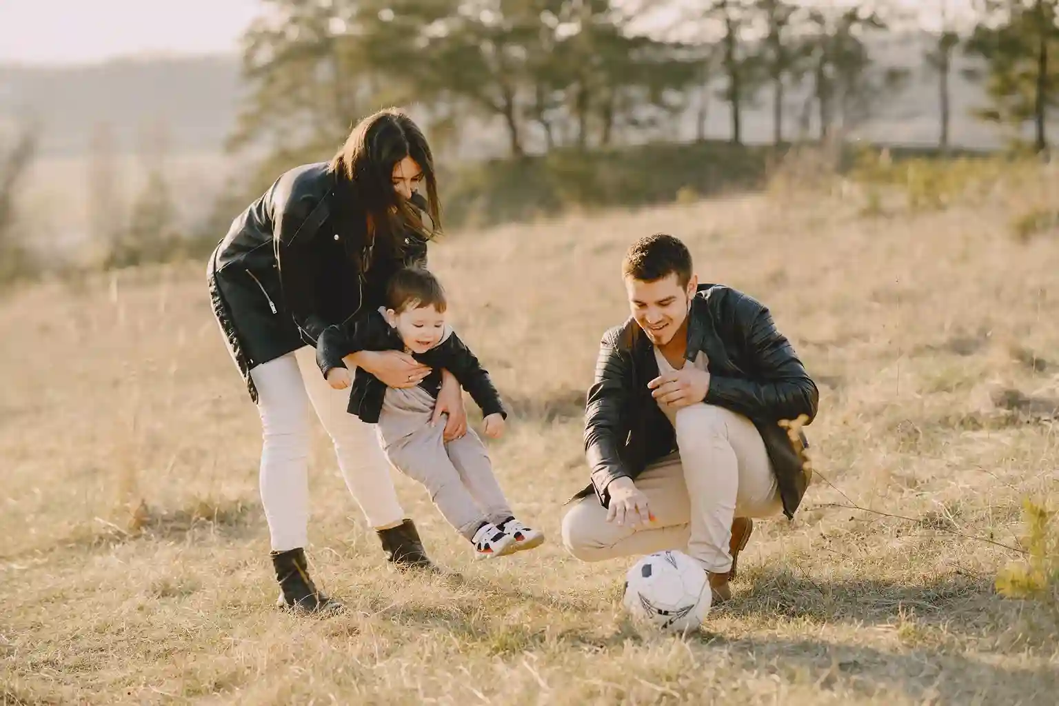young family playing soccer with child