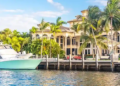 A luxury mansion in Florida with a boat in front of it.