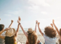 A group of friends sitting on the beach.