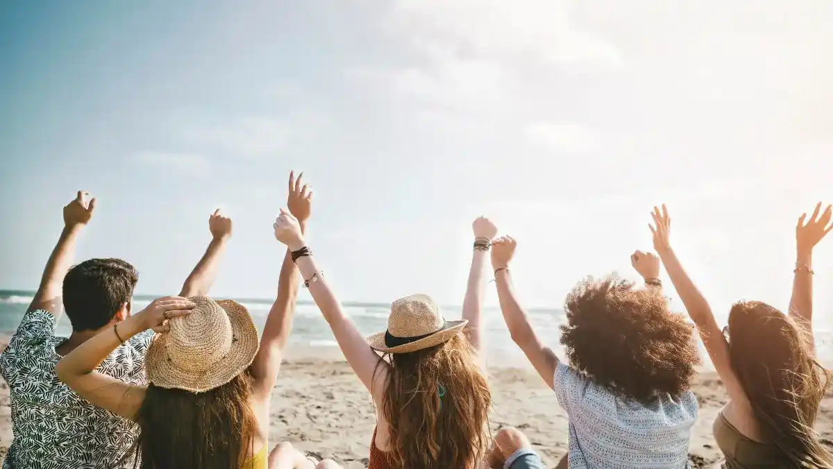 A group of friends sitting on the beach.