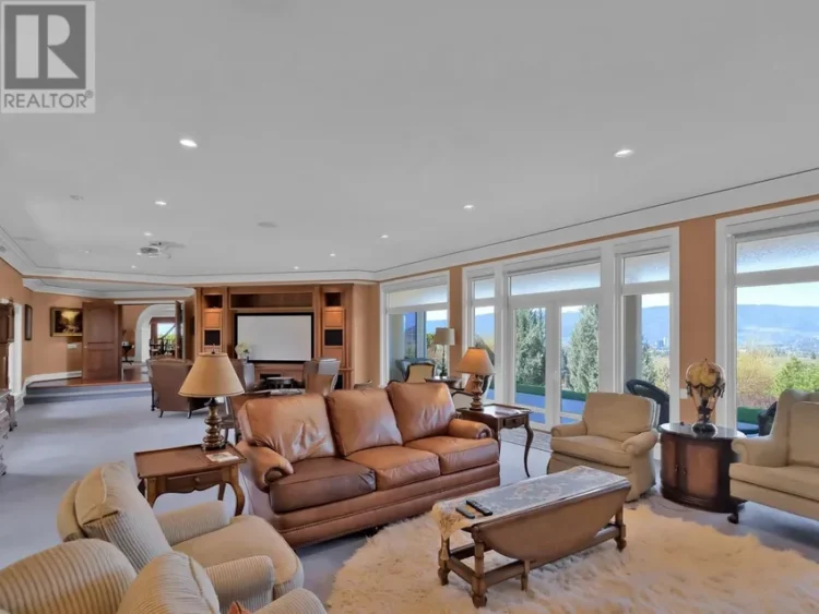 A spacious living room featuring a large window and a couch.