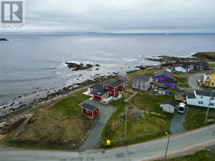 A coastal view featuring a red house overlooking the ocean.