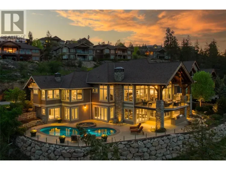 A large home with a pool against a vibrant sunset sky.