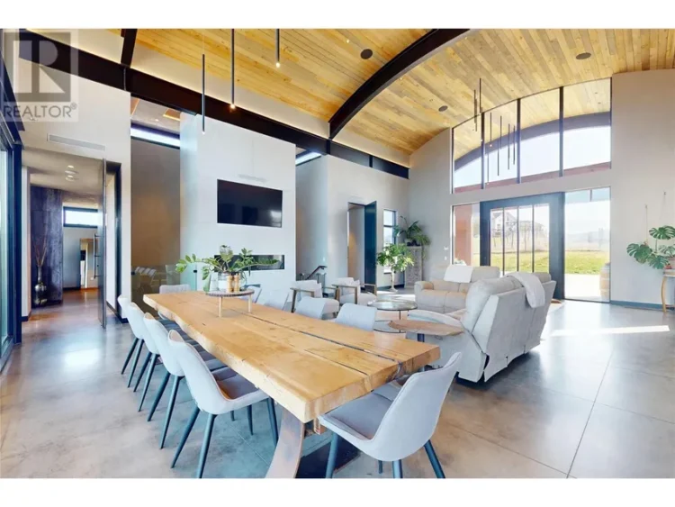 A spacious living room featuring a large dining table, surrounded by comfortable seating.