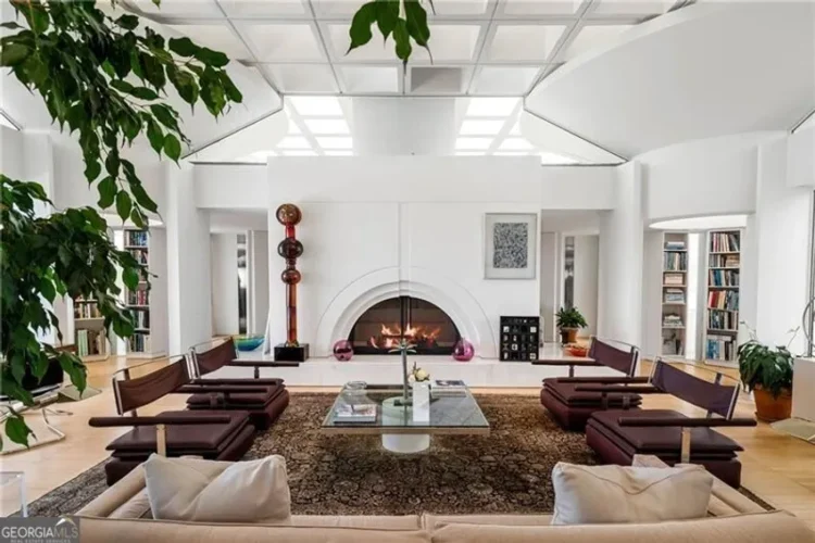 A living room with a fireplace and shelves lined with books.