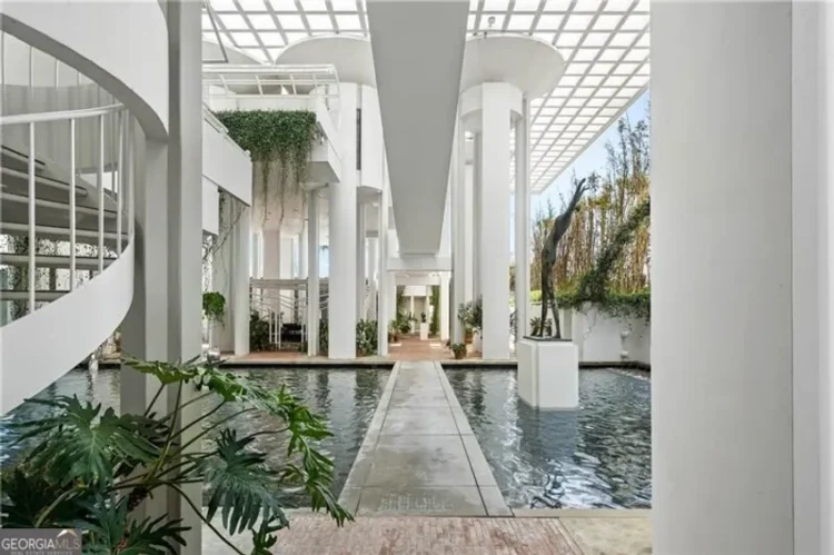 An indoor pond with greenery and a walkway.