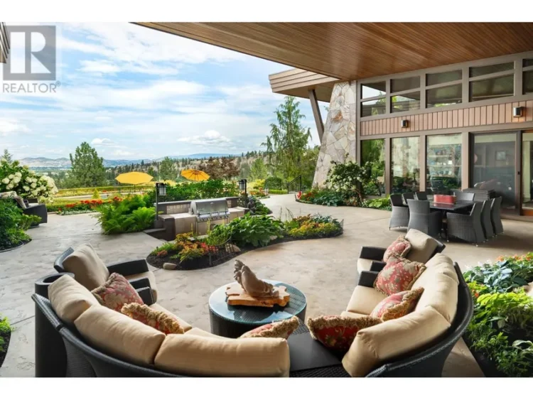 Outdoor furniture arranged on a patio overlooking mountains in the distance.