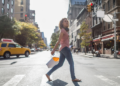 A woman walks across the street in New York City