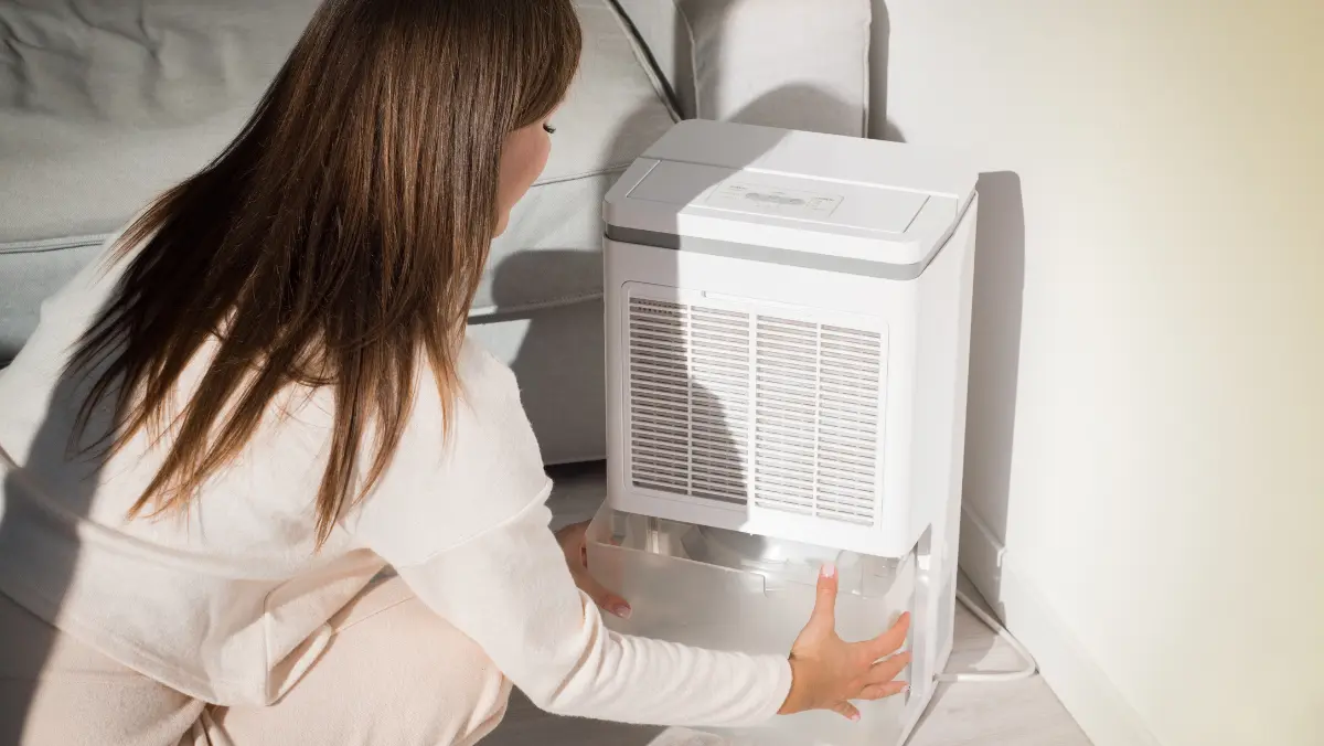 A woman examines a white air conditioner.