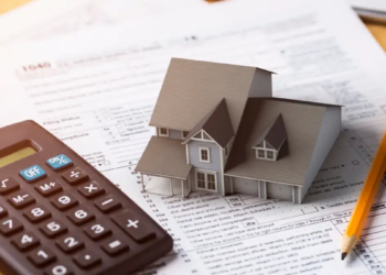 A house model placed on tax documents.