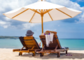 Two people sitting on beach chairs at the beach