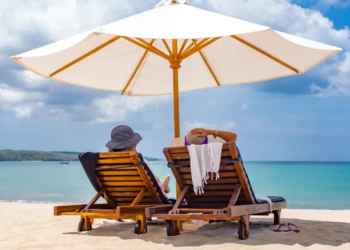 Two people sitting on beach chairs at the beach