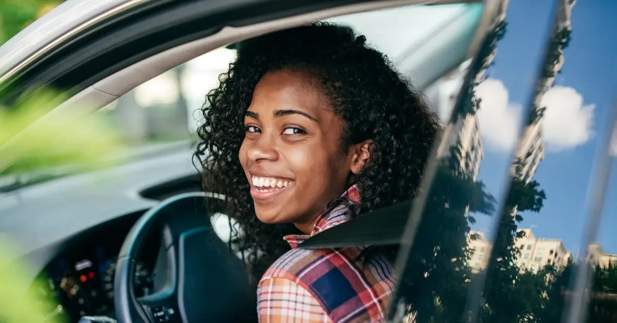A woman sitting in the driver's seat of a car