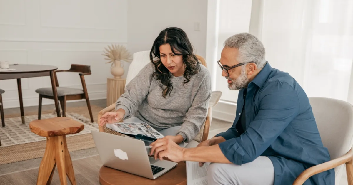 A couple looks at a laptop screen wondering if it is time to downsize their home.