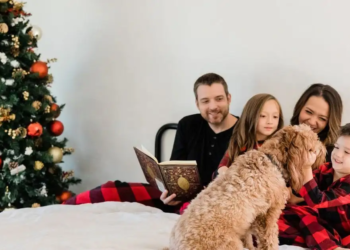 family reading together in bed with dog