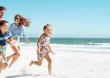 family running on the beach