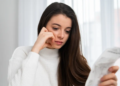 A woman looks at her bills regretfully.