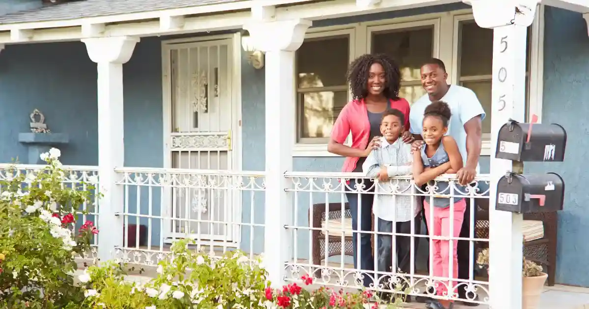 A family stands on a porch outside