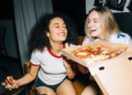 Two friends eating pizza