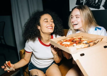 Two friends eating pizza