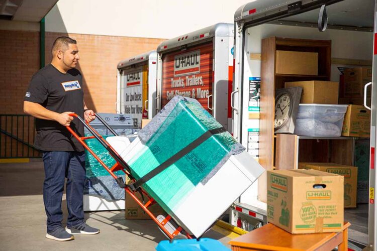 Man moving appliance into a moving truck