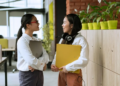 two young coworkers chatting in the office