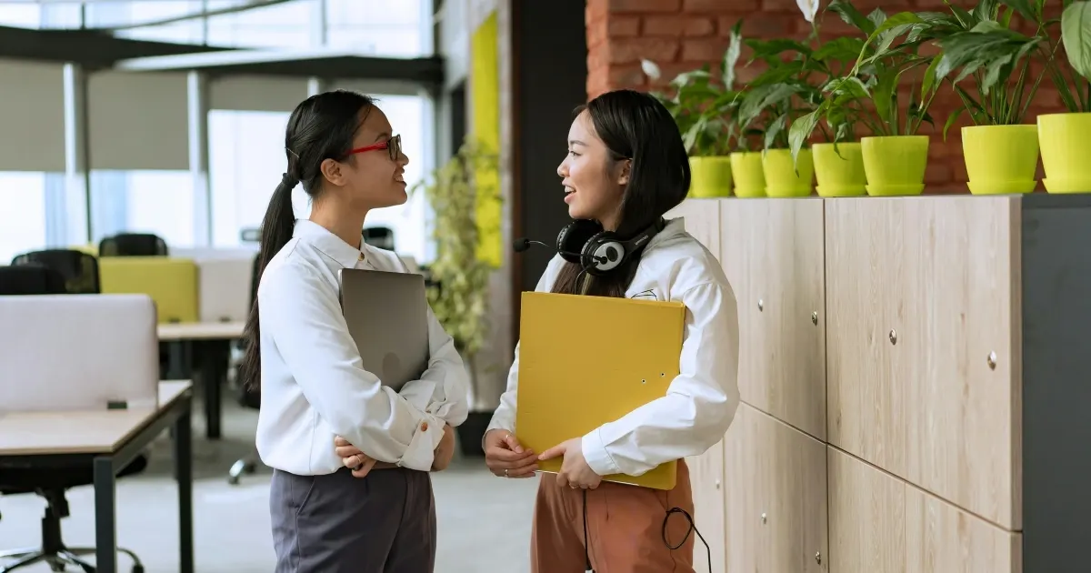 two young coworkers chatting in the office
