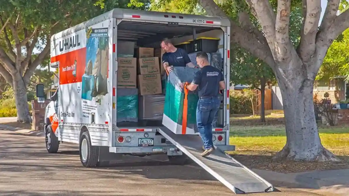 Two Moving Help moving labor providers carefully load a washing machine into a U-Haul truck rental.