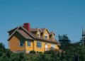 yellow canadian home with blue sky in background