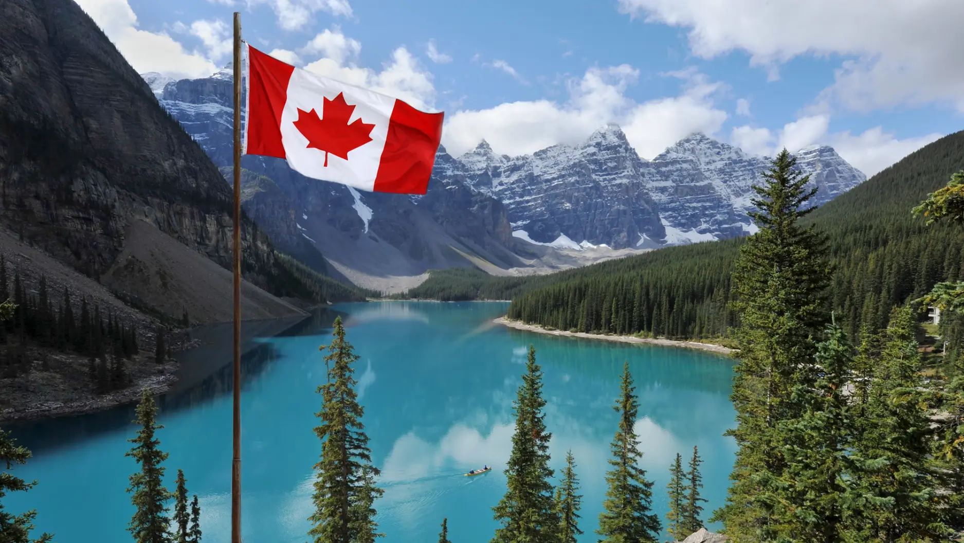 Canadian flag in front of lake and mountains